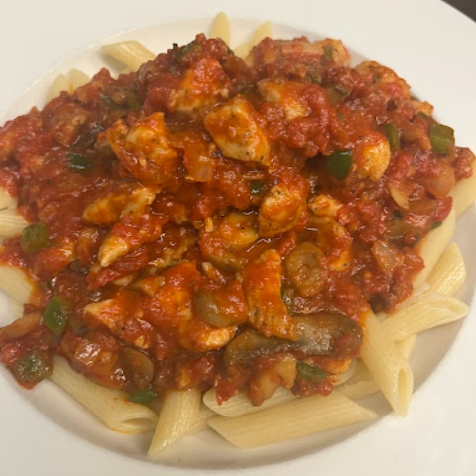Penne pasta topped with chicken, mushrooms, and green peppers in a rich red tomato sauce.